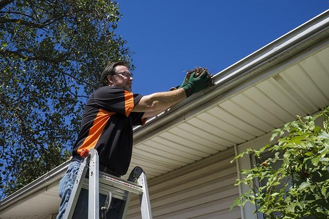 home renovation worker replacing broken gutter sections in Caldwell NJ